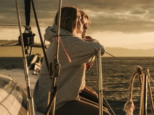 Girls on a sailboat watching the sunset.